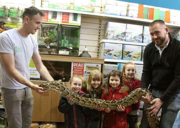 Eevie Reid, Ellie Hacket, Rosie Rogers and Imogen Quade have a close encounter with a Burmese python held by Tom Charlton from Eco Animal Encounters, left, and Sam Baker, managing director of Aquajardin at a reptile event at Garssons