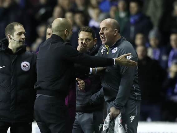Paul Cook, right, and Pep Guardiola go head to head on the touchline during last night's FA Cup tie between Wigan and Manchester City