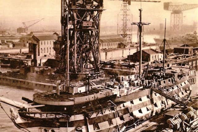 It is 1949 and HMS Implacable has her heart ripped out as her main mast is lifted from her hull.  Picture: Robert James Collection