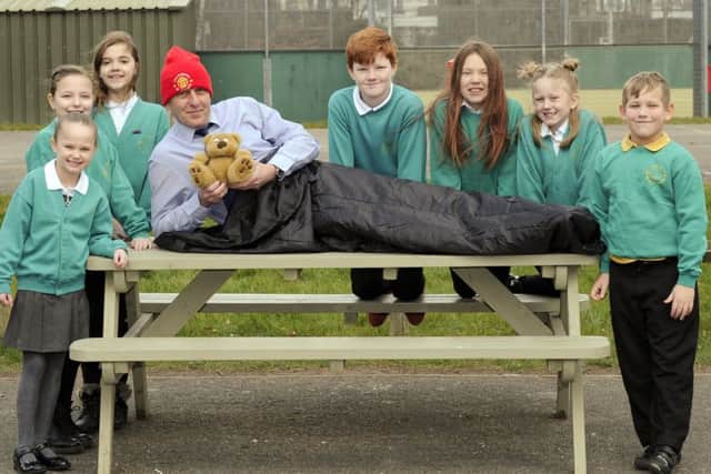 Pupils wish headteacher Howard Payne well as he tries out his sleeping bag along with his favourite Manchester United hat and of course his teddy bear with, from left: Elsie Roberts, Calleigh Hird, Trinity Benford, Paul Jacques, Sienna Smart, Lola Wilbur, and Archie Crump     Picture:  Malcolm Wells (180226-5623)