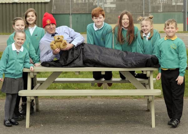 Pupils wish headteacher Howard Payne well as he tries out his sleeping bag along with his favourite Manchester United hat and of course his teddy bear with, from left: Elsie Roberts, Calleigh Hird, Trinity Benford, Paul Jacques, Sienna Smart, Lola Wilbur, and Archie Crump     Picture:  Malcolm Wells (180226-5623)