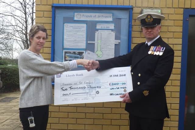 The cheque for Â£2,000 is handed over to the school