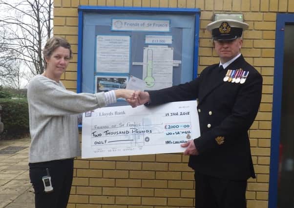 The cheque for Â£2,000 is handed over to the school