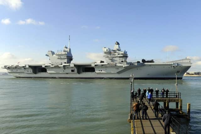 HMS Queen Elizabeth makes her way into Portsmouth Harbour and the Naval Base 

Picture by:  Malcolm Wells (180227-7944)