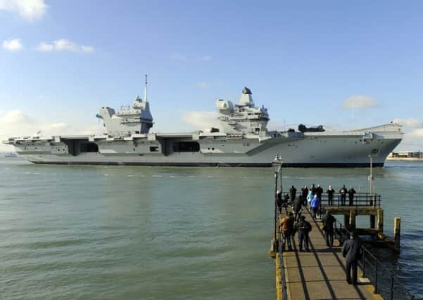 HMS Queen Elizabeth makes her way into Portsmouth Harbour and the Naval Base 

Picture by:  Malcolm Wells (180227-7944)