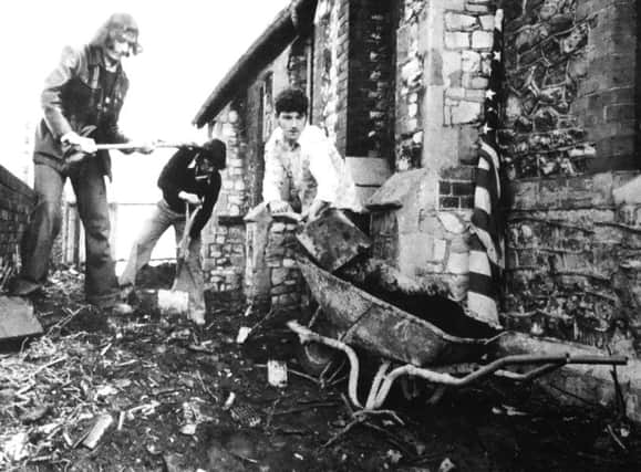 Left to right, Peter Smith, 25, Tony Crowling, 18, and Reg Berry, 17, clearing the ground