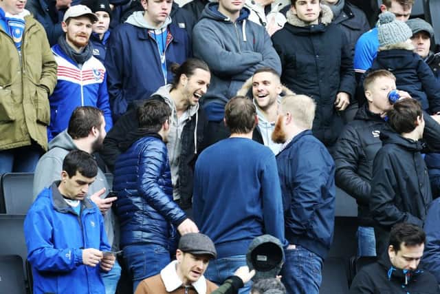 Stuart O'Keefe and Christian Burgess share a joke with fans at MK Dons. Picture: Joe Pepler