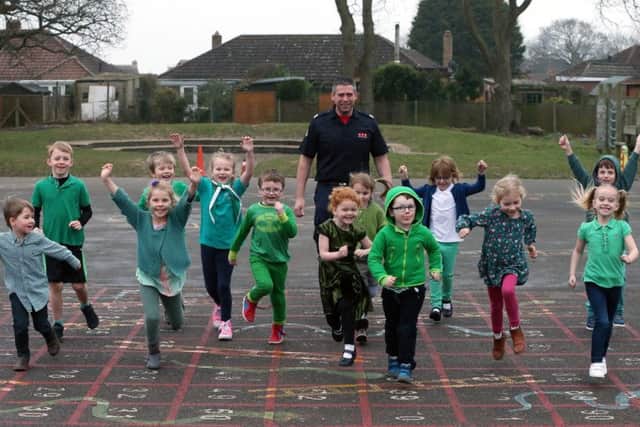 Pupils of Crofton Hammond Infant School, Stubbington help firefighter Chris Secrett train for the marathon on their Green For Grenfell day Picture: Chris Moorhouse