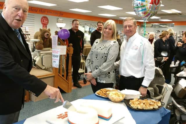 Alderman Derek Kimber (left) cutting the cake with Directors Debbie and Michael Watts (right) and Solent Mobility Team and shoppers