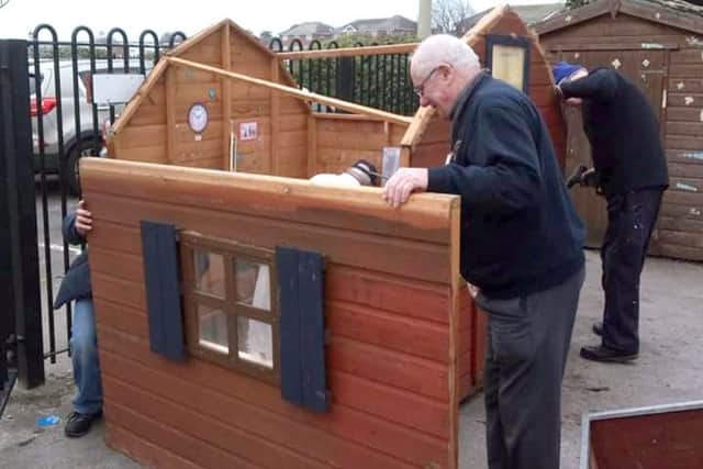 Members of Gosport Men's Shed repairing a playhouse at Alverbridge Nursery