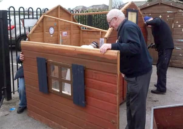 Members of Gosport Men's Shed repairing a playhouse at Alverbridge Nursery