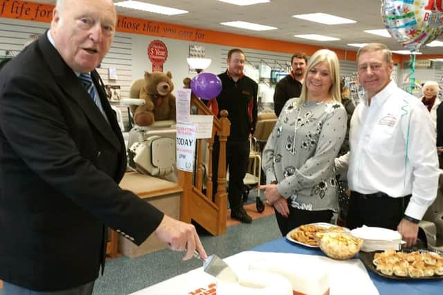 Honorary Alderman Derek Kimber (left) cutting the cake with Directors Debbie and Michael Watts (right) and the Solent Mobility team and shoppers