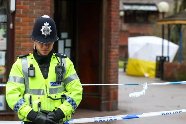 A policeman next to a cordon near to a bench in the Maltings shopping centre in Salisbury, as police and members of the armed forces probe the suspected nerve agent attack on Russian double agent Sergei Skripal. Andrew Matthews/PA Wire