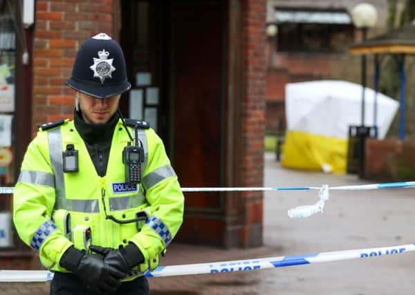 A policeman next to a cordon near to a bench in the Maltings shopping centre in Salisbury, as police and members of the armed forces probe the suspected nerve agent attack on Russian double agent Sergei Skripal. Andrew Matthews/PA Wire