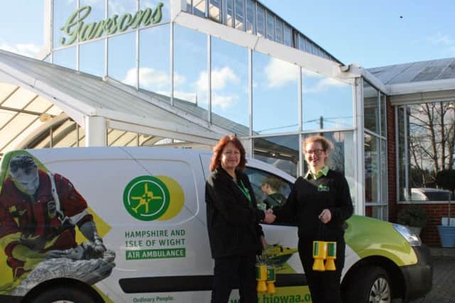 Carol Chapman, HIOWAA volunteer, hands collection boxes to Lauren Bennett, Garsons assistant manager
