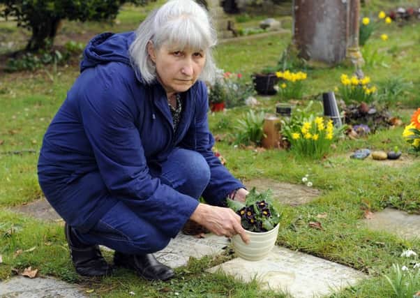 Jackie Quinn tends her husband's memorial stone   Picture:  Malcolm Wells