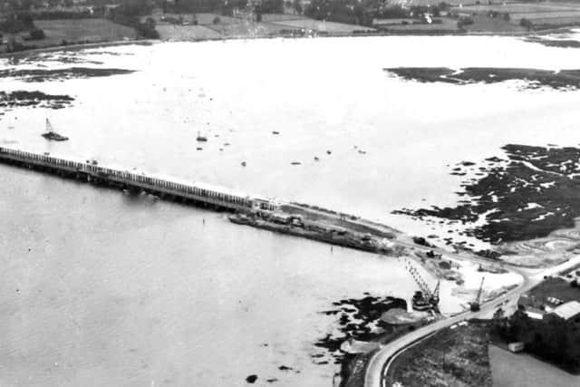 In this rare photograph we see the new Langstone road bridge (top) under construction with the old wooden bridge alongside. It opened in 1956.