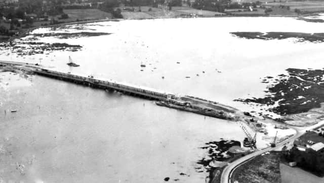 In this rare photograph we see the new Langstone road bridge (top) under construction with the old wooden bridge alongside. It opened in 1956.