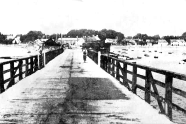 A lone cyclist crosses Langstones old wooden bridge. The Royal Oak pub is on the far right.