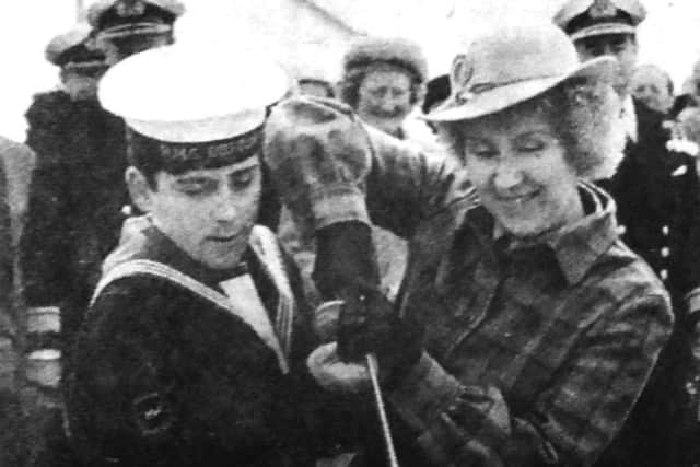 Phillip Hutchings, 17, Brecons youngest sailor helps Pearl Birkett, the ships commanding officers wife, cut the commissioning cake