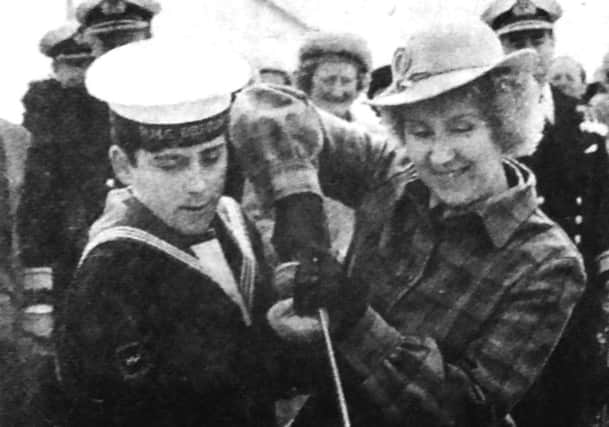 Phillip Hutchings, 17, Brecons youngest sailor helps Pearl Birkett, the ships commanding officers wife, cut the commissioning cake