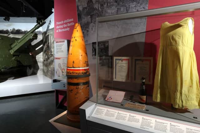 A British 25 pounder gun gun, a naval 15 inch shell of the type that would have been fired from a battleship, and a shift dress made from parachute silk in the refurbished D-Day Story museum