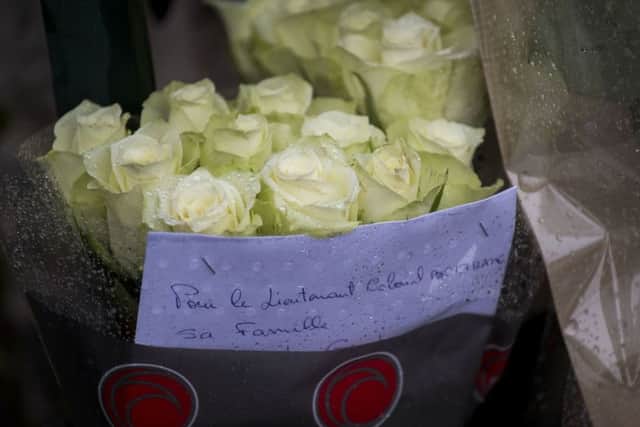 Flowers are placed at the main gate of police headquarters in Carcassonne, France, (AP Photo/Emilio Morenatti)