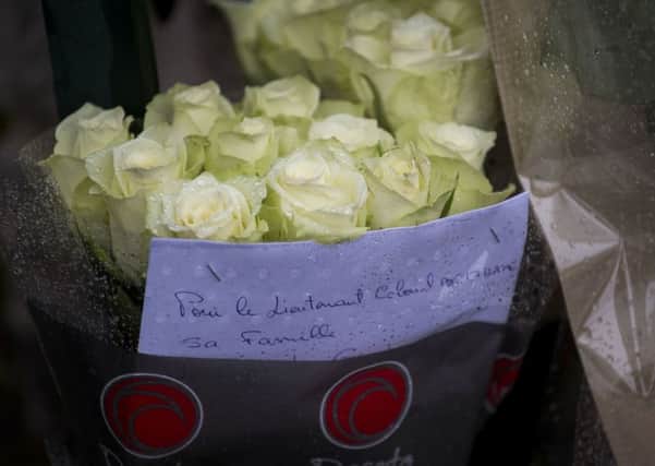Flowers are placed at the main gate of police headquarters in Carcassonne, France,  (AP Photo/Emilio Morenatti)