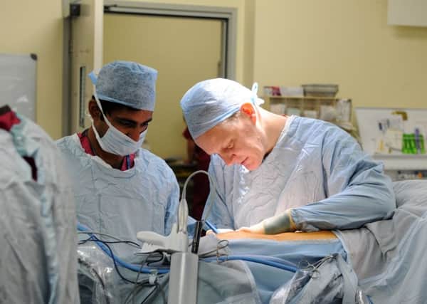 A surgeon at work in the operating theatre at QA Hospital
