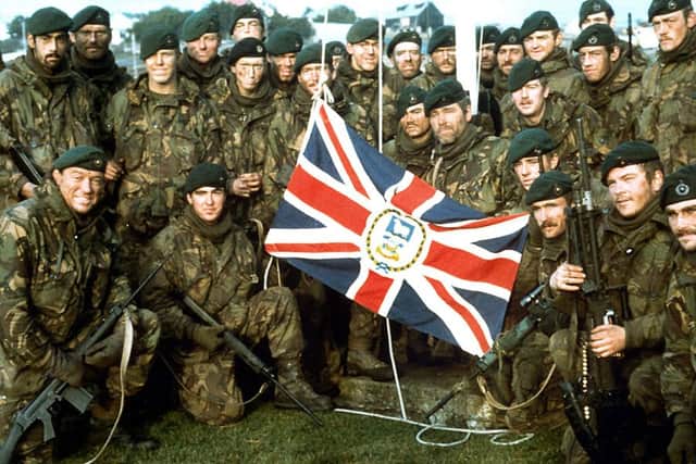 Fight of South Georgia - Royal Marines Naval Party 8901, the Royal Marine garrison of the Falkland Islands evicted by the Argentine invaders, with the Falkland Islands flag outside Government House, Port Stanley, after the Argentine surrender.