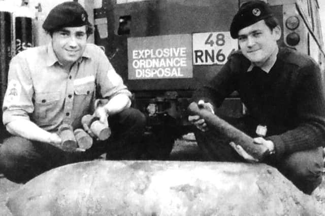 Two members of the Portsmouth and Medway Clearance Diving Team at HMS Vernon with the 250lb German bomb which was dredged up at Albert Johnson Quay. On the left LS(D) M O'Learey with some of the high explosive content of the bomb and AB C Carr with the fuse