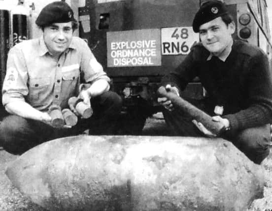 Two members of the Portsmouth and Medway Clearance Diving Team at HMS Vernon with the 250lb German bomb which was dredged up at Albert Johnson Quay. On the left LS(D) M O'Learey with some of the high explosive content of the bomb and AB C Carr with the fuse