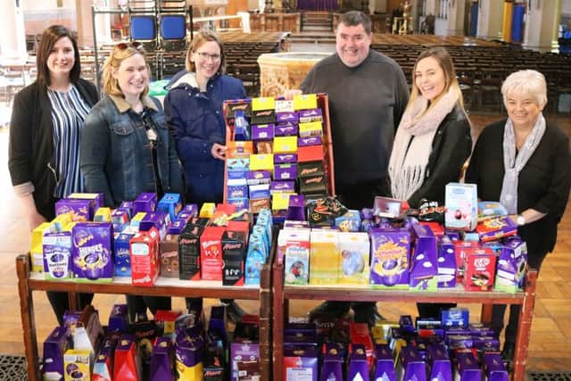 Canon Bob White (centre) with some of the 500 chocolate Easter eggs donated by churchgoers to help needy families this Easter