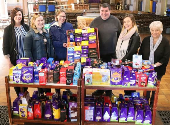 Canon Bob White (centre) with some of the 500 chocolate Easter eggs donated by churchgoers to help needy families this Easter