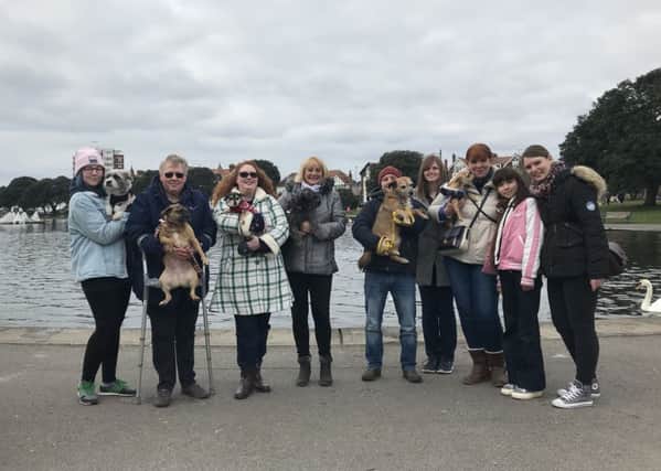 Grace Piper and Dixie, third-left, get ready to set off on a stroll from Canoe Lake in Southsea with fellow small dog owners from Portsmouth. Picture: Byron Melton