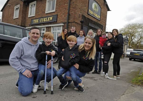 The Walking Fund charity has hosted the last ever fundraising event for Oakley Smith at The Curlew public house in Havant. From left at the front, dad Terry Smith, Oakley and his brother Mykey, eight, and mum Angie Mahon 
Picture Ian Hargreaves  (180445-1)