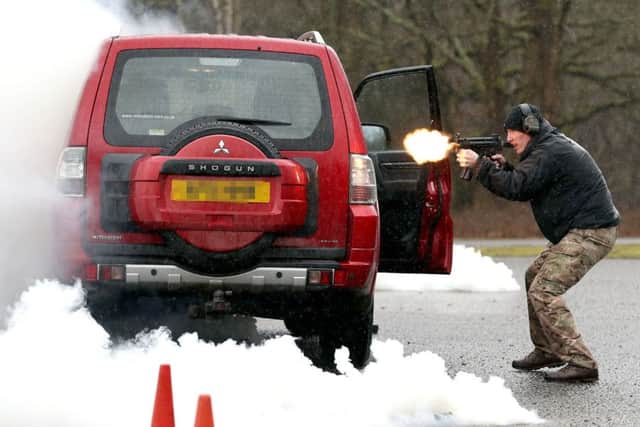 A soldier playing the enemy opens fire, as members of the Close Protection Unit Royal Military Police carry out a demonstration during the NATO Military Police Close Protection conference. PHOTO: Andrew Mathews/PA Wire