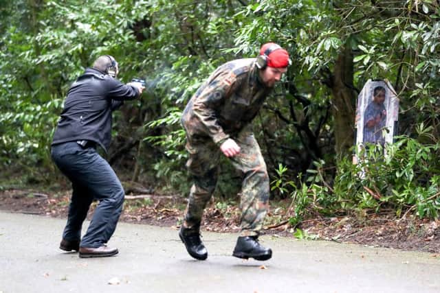 A member of the Close Protection Unit Royal Military Police (left) protects a delegate playing a VIP as part of a demonstration during the NATO Military Police Close Protection conference at Longmoor Training Camp in Hampshire. PHOTOL Andrew Mathews/PA Wire