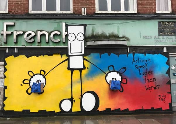 The My Dog Sighs mural with shopping bags attached