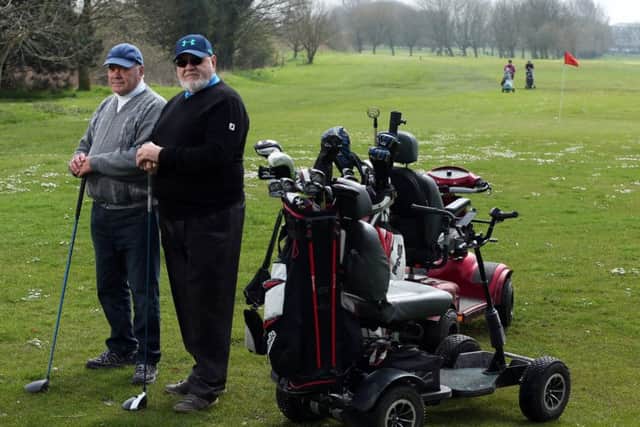 Golfers Graham Marks, left, and Robert Reeds with their buggies