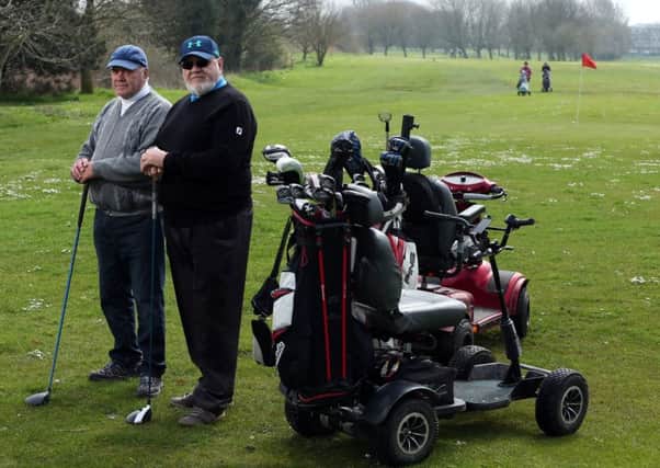 Golfers Graham Marks, left, and Robert Reeds with their buggies