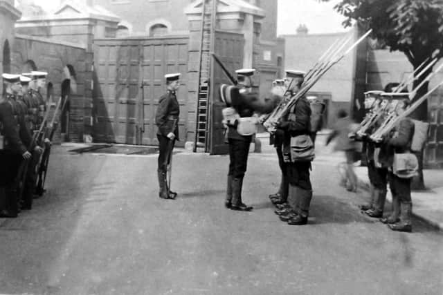 With long gunnery gaiters and sword bayonets fixed to their rifles, we see marines changing guard just inside Eastney Barracks main gate. Robert James Collection