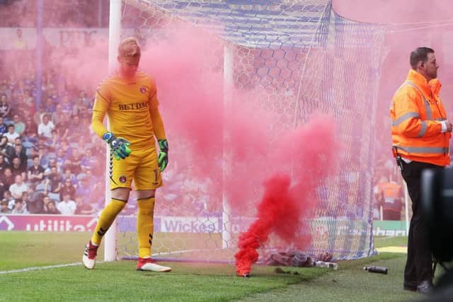 A smoke bomb lands on the pitch next to Charlton keeper Ban Amos Picture: Joe Pepler