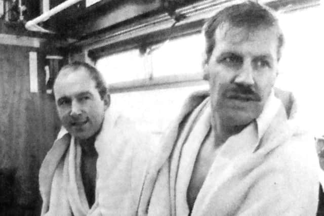 The two frozen firemen, Bob Rowson, left, and Bill Spivey wrapped in blankets after diving in the submerged car