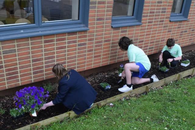 Henry Cort Community College pupils starting on the flower memorial