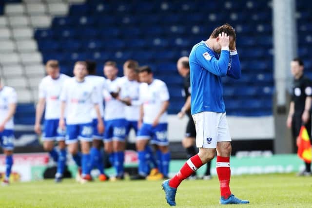Brett Pitman holds his head in his hands as the Bury players celebrate George Miller's goal