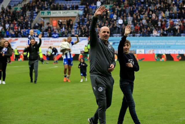 Paul Cook leads his Wigan team on a lap of honour after the match