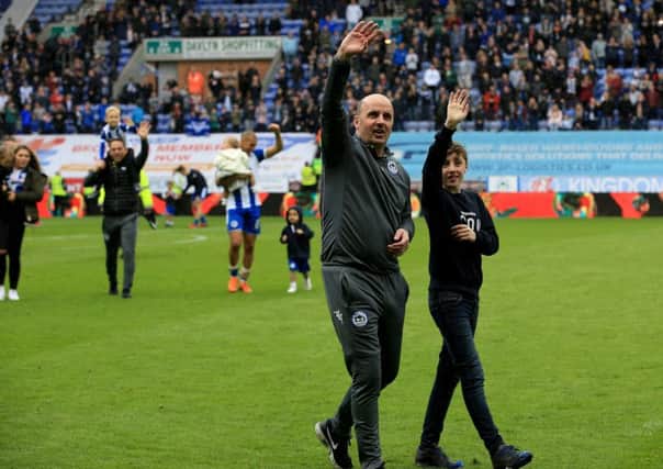 Paul Cook leads his Wigan team on a lap of honour after the match