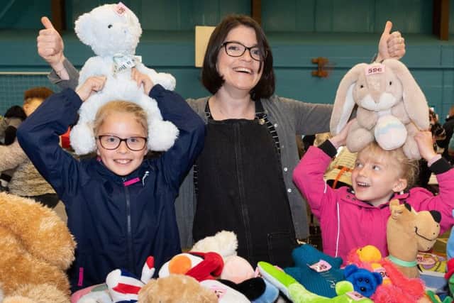 Aimee, 8 and Grace Wheeler, 5 with Rachel Sinclair at the teddy bear tombola stall.
Picture by Keith Woodland