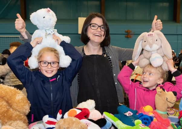 Aimee, 8 and Grace Wheeler, 5 with Rachel Sinclair at the teddy bear tombola stall.


Picture by Keith Woodland